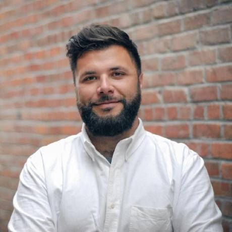 Ian Hoar, who makes Hop Tales, smiling in front of a brick wall